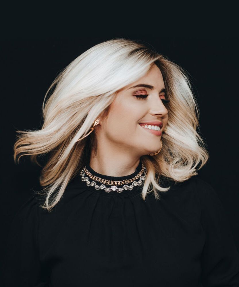 Photo of woman with blonde hair smiling and swinging hair